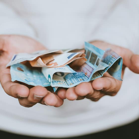 Manos ofreciendo billetes de euro